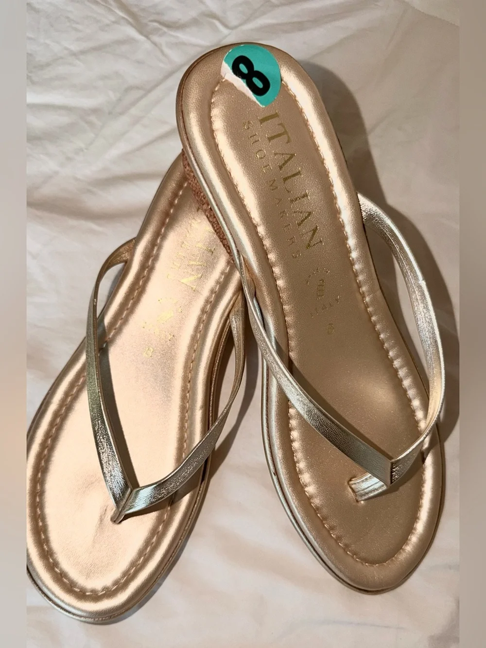 Italian Shoemakers thong wedge sandals feature a metallic gold finish